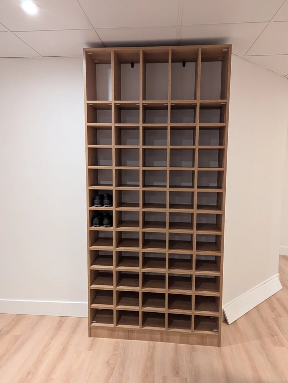 Étagère murale sur mesure en mélamine avec compartiments pour chaussures, installée dans un spa premium à Laval