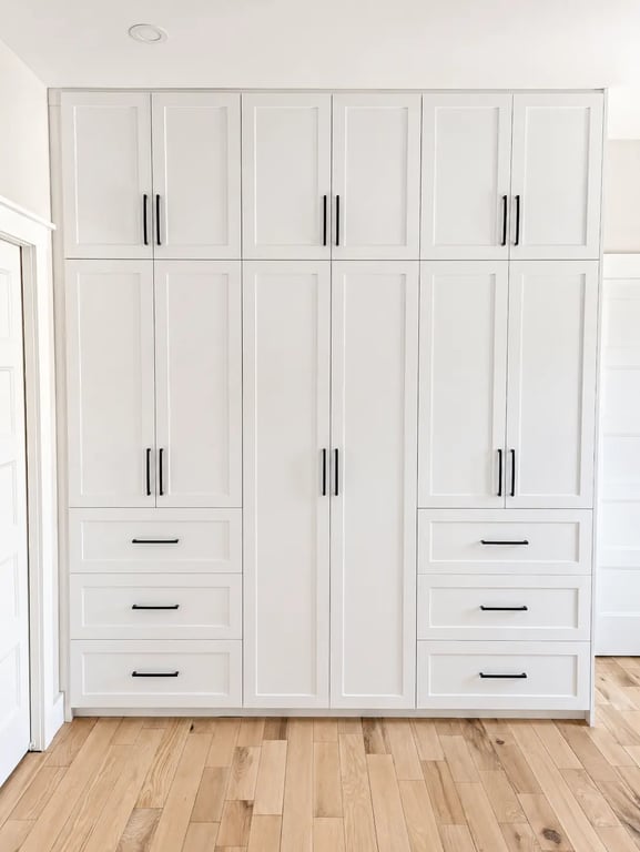 Garde-robe encastrée blanche de style Shaker avec 6 tiroirs et poignées noires, projet réalisé à Saint-Jérôme, Rive-Nord de Montréal.