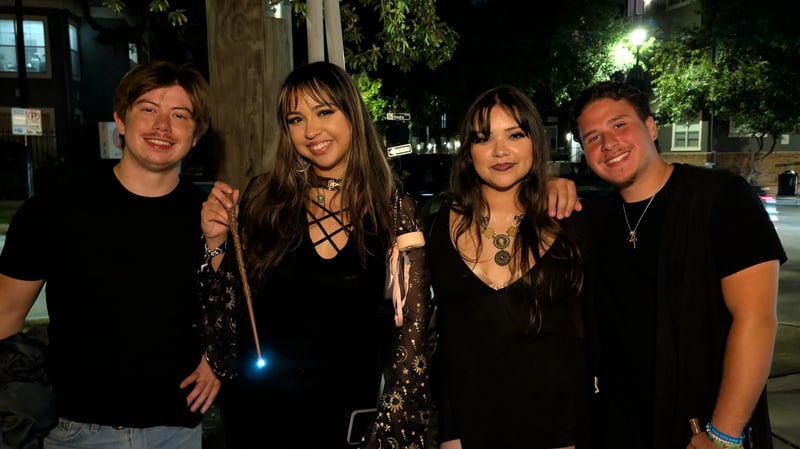 Four Wizards Night Out friends on a city sidewalk at night, one casting with a glowing wand