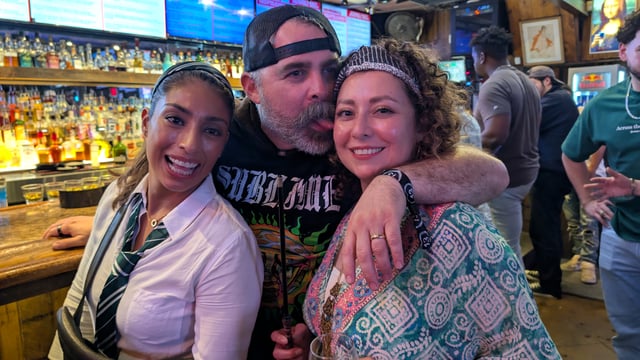 Slytherin witch and tiara-topped birthday witch get a smooch from their muggle pal on the wizard crawl