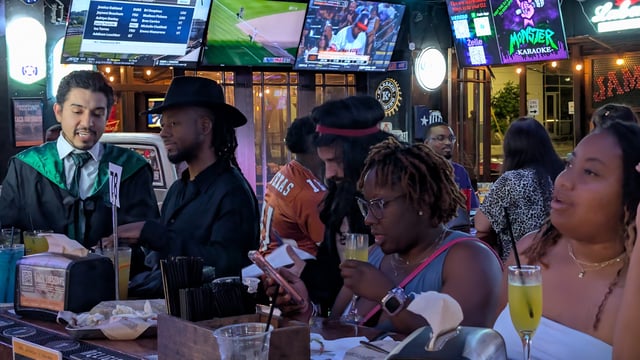 Robed bartender takes mimosa orders from a Wizards Night Out crew at a patio bar table