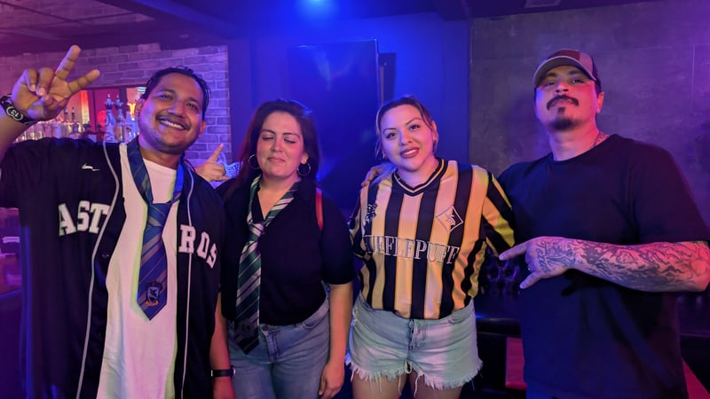 Wizards Night Out crew in house ties and a Houston Astros-Wizards jersey in a blue-lit bar