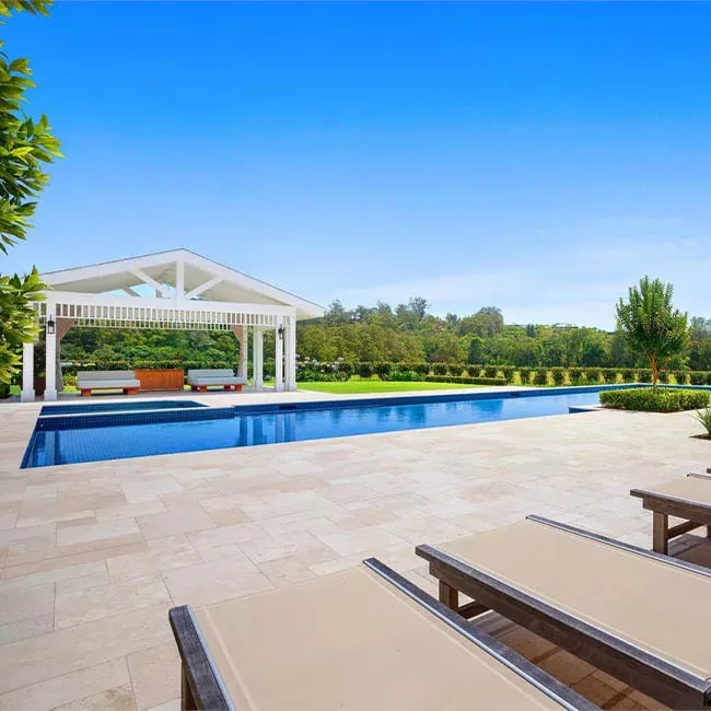 A picture of travertine pavers around a pool in Melbourne.