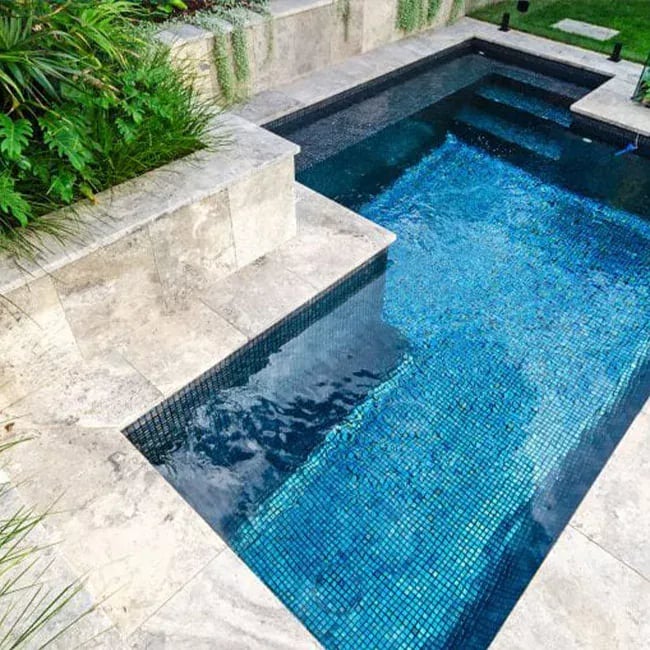 A picture of travertine pavers around a pool in Melbourne.