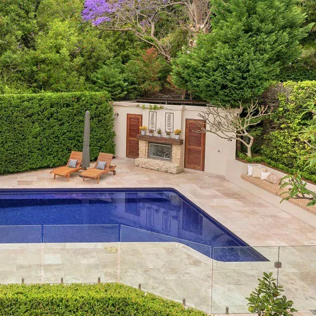 A picture of ivory travertine pavers around a pool in Melbourne.