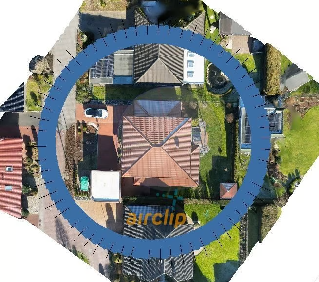 Aerial photo of a detached house surrounded by a blue ring; the ticks on it are the capture points. The house sits exactly in the centre of the ring.
