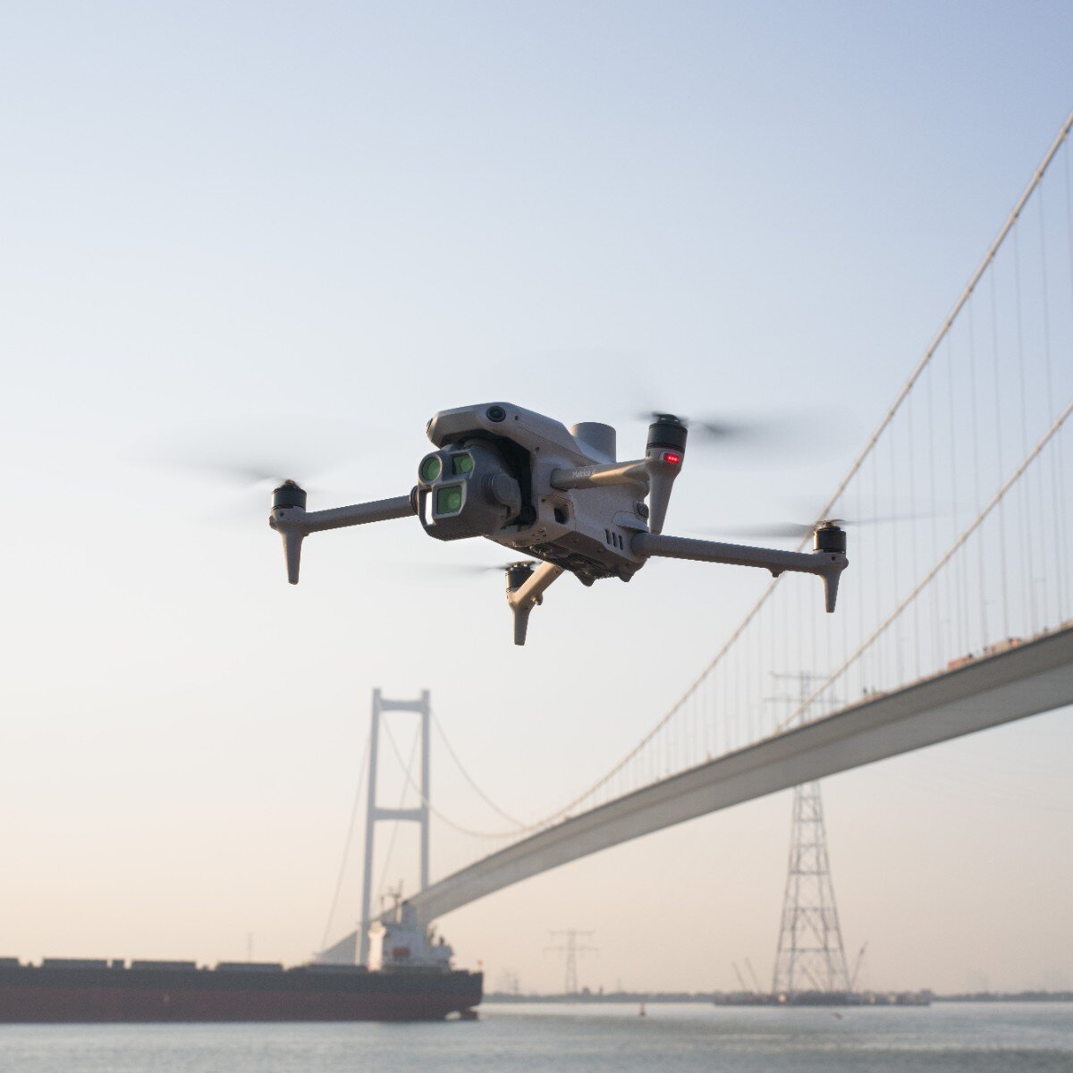 DJI Matrice 4E in flight in front of a suspension bridge