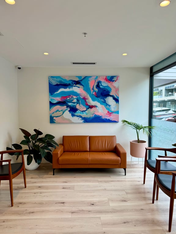 The Aevum waiting room, with a leather sofa and abstract painting
