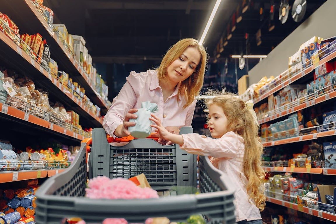 Mother and child looking at food labels in a grocery aisle