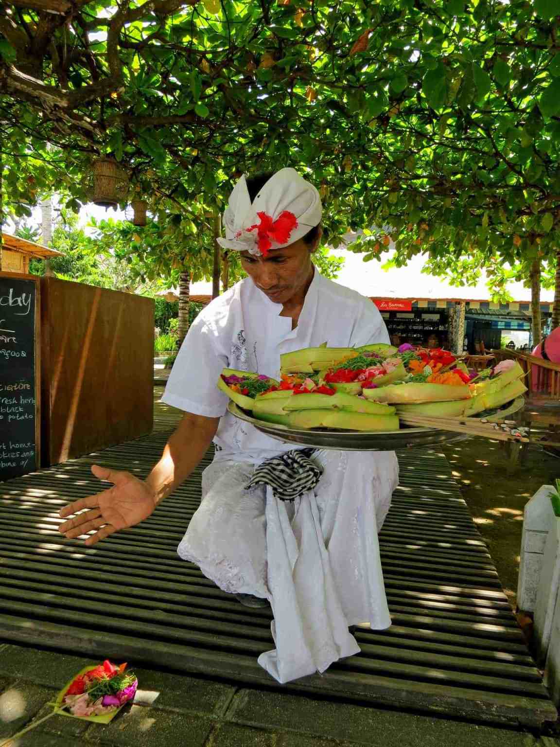 Balinese man laying out an offering