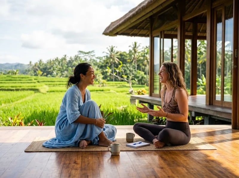 Two women talking on a wooden deck overlooking rice fields