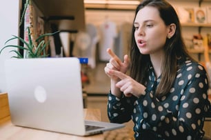 The Power of Empathy focused young woman having video call on netbook in modern workspace