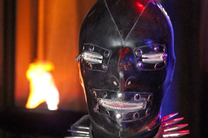 Futuristic robot head with glowing red eyes and zippers