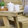 Rustic wooden outdoor patio table with white ceramic mugs, teapot, and potted plant, perfect for garden relaxation and outdoor entertaining.