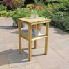 - Wooden outdoor patio side table with glass pitcher and tumbler set on a garden stone patio.