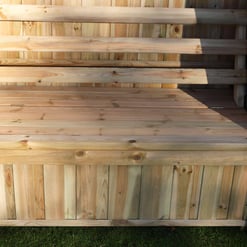 Natural cedar wood outdoor storage bench with backrest, ideal for garden and patio seating. Robust and weather-resistant construction perfect for outdoor home and garden use.