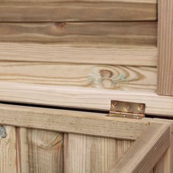 Untreated wood storage shed with hinges on a brick wall, ready for assembly, perfect for outdoor garden storage solutions.
