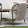 Modern outdoor lounge chair with beige cushion and green metal frame, perfect for patio or garden relaxation.