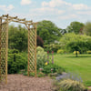 Lattice garden archway surrounded by lush greenery in a beautifully landscaped backyard. Perfect for adding elegance and structure to outdoor living spaces. Ideal for garden design and backyard improvement.