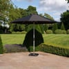 Black patio umbrella on a landscaped garden patio with manicured bushes and trees, perfect for outdoor relaxation and shade.