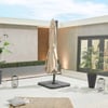 Modern outdoor patio with beige umbrella, potted plants, lanterns, and cozy rug, perfect for outdoor living and entertaining. Stylish design enhances your home's garden and patio space.
