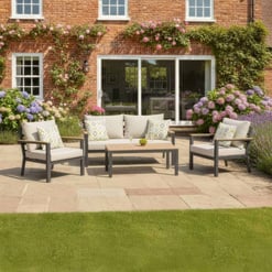 Stylish outdoor patio furniture set with comfortable cushions and decorative pillows, perfect for relaxing in a beautifully landscaped garden area with blooming flowers and lush greenery.