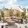 Relaxing outdoor patio with modern wicker sectional sofa, sunshade umbrella, decorative pillows, lanterns, and lush greenery creating an inviting garden retreat.