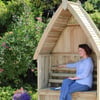 Handmade wooden garden nook with roof, perfect for relaxing outdoors in a lush garden setting, ideal for outdoor living and backyard furniture.