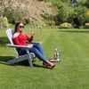 Relaxing woman enjoying garden lawn with wine, outdoor patio furniture, and lush greenery for garden and outdoor living inspiration.
