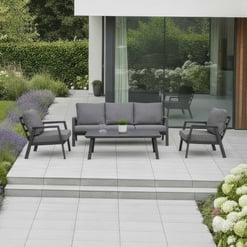 Modern outdoor patio furniture set with gray cushioned seating, coffee table, and stylish garden landscaping, perfect for outdoor living spaces and garden design.