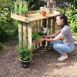 Lush garden planter stand with a woman watering and tending potted plants outdoors, showcasing garden accessories and outdoor gardening tools for home and garden enthusiasts.
