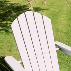 Adirondack chair on a lush green lawn with tree shadows, perfect for outdoor garden relaxation and patio decor.