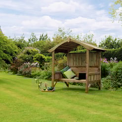 Beautiful backyard garden with a cozy wooden outdoor canopy, lush greenery, flowering plants, and garden decor, perfect for relaxing and outdoor living.