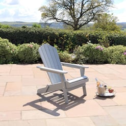 Adirondack chair on a patio overlooking scenic garden and rolling hills in the countryside.