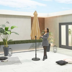 Modern rooftop patio with large umbrella, stylish decor, potted plants, and cozy seating area for outdoor living and garden design.