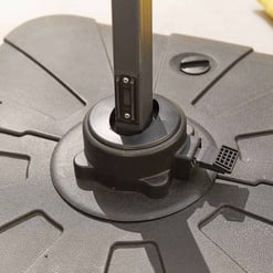 Adjustable patio umbrella base with wheel and tilt mechanism for outdoor garden and patio furniture.