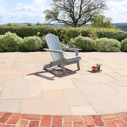 Relaxing outdoor patio with Adirondack chair and garden plants, ideal for backyard garden and outdoor living.