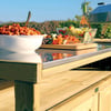 Fresh outdoor catering station with a bowl of pasta, colorful skewers, and a chafing dish set against a scenic vineyard backdrop for garden entertaining.
