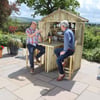 Handcrafted wooden garden bar with two men enjoying outdoor drinks in a beautifully landscaped garden, perfect for outdoor entertaining and backyard bar setups.