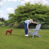 Vibrant outdoor garden scene with a woman and her dog, showcasing garden furniture from Empire Home and Garden, perfect for outdoor relaxation and entertaining.