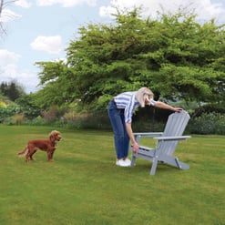 Vibrant outdoor garden scene with a woman and her dog, showcasing garden furniture from Empire Home and Garden, perfect for outdoor relaxation and entertaining.