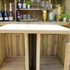 Rustic outdoor wooden bar with ample shelving for drinks and glassware, ideal for garden entertainment and outdoor living spaces. Perfect for home bar setup and backyard gatherings.