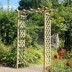 Wooden garden arbor with lattice sides and an open overhead trellis in a lush, vibrant garden with colorful flowers and greenery, ideal for outdoor landscaping and garden decor projects.