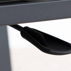 Adjustable black plastic foot leveler on a gray metal table or furniture piece for stability, part of modern home or garden furniture from Empire Home and Garden.