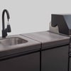 Modern commercial kitchen sink with black faucet and stainless steel countertop, ideal for food prep and cleaning in restaurant or catering environments.