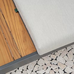 Elegant outdoor patio furniture with wooden slats, a cushioned seat, and durable metal frame on a stone paver surface, perfect for stylish garden or backyard relaxation.