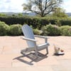 Adirondack chair on patio overlooking a lush garden and rolling hills, perfect for outdoor relaxation and enjoying scenic views.