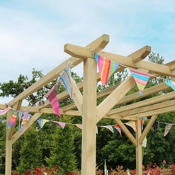 Colorful striped pennant banners hanging on a wooden garden pergola, outdoor backyard setting, perfect for garden decor and summer celebrations, from Empire Home and Garden.