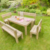 Wooden outdoor garden dining table and benches set on lush green lawn with colorful flower garden in the background, perfect for outdoor entertaining and garden decor.