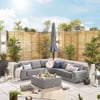 Stylish outdoor patio with cozy gray sectional sofa, decorative pillows, lush green plants, modern lanterns, and a privacy wooden fence, perfect for relaxing outdoor living.